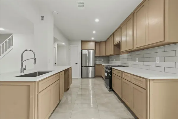a kitchen with stainless steel appliances granite countertop a sink and cabinets