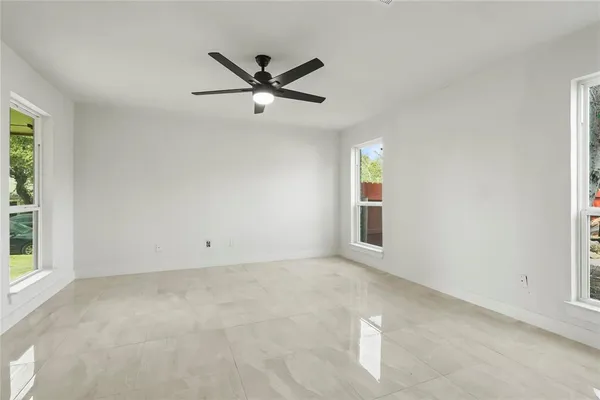 a view of a big room with wooden floor and windows