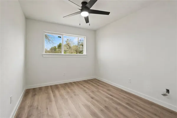 an empty room with a window and a fan