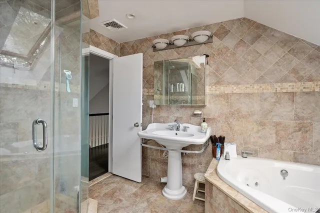 a bathroom with a bathtub sink and mirror
