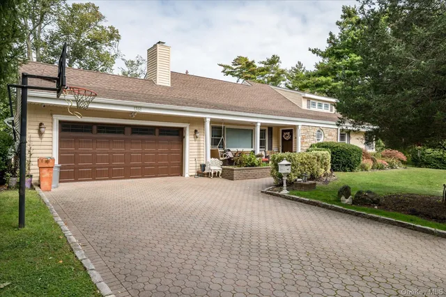 a front view of a house with a yard and potted plants