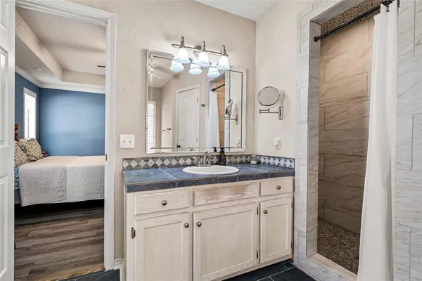 a bathroom with a granite countertop double vanity sink and a mirror