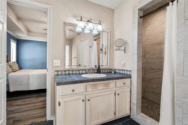 a bathroom with a granite countertop double vanity sink and a mirror