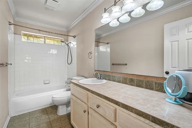 a bathroom with a granite countertop sink a toilet and bathtub