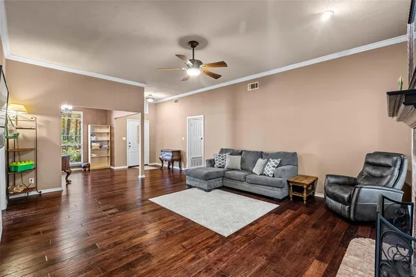 a living room with furniture and a wooden floor