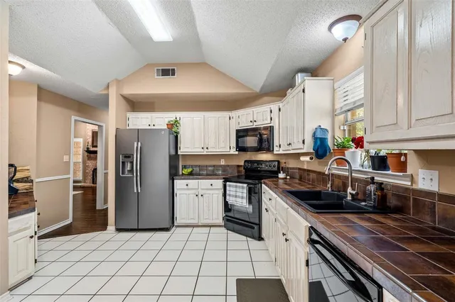 a kitchen with stainless steel appliances a refrigerator a stove a sink and a counter space