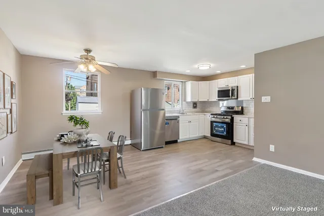 a kitchen with white cabinets and refrigerator