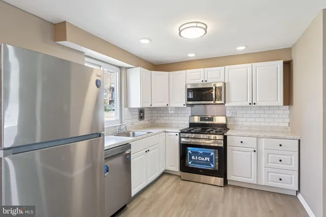 a kitchen with stainless steel appliances granite countertop a refrigerator stove and sink