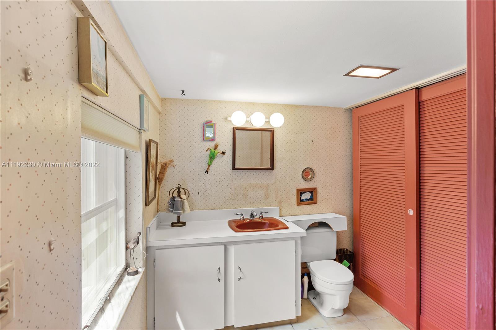 Riviera Coral Gables, FL 33146 - Photo 25 of 39 a bathroom with a sink a toilet a mirror and shower curtain