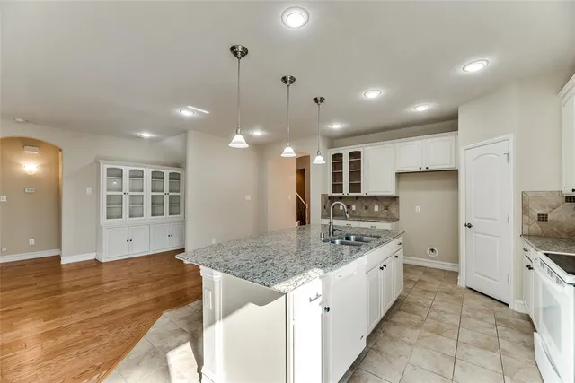 a large kitchen with kitchen island a counter space a sink stainless steel appliances and cabinets