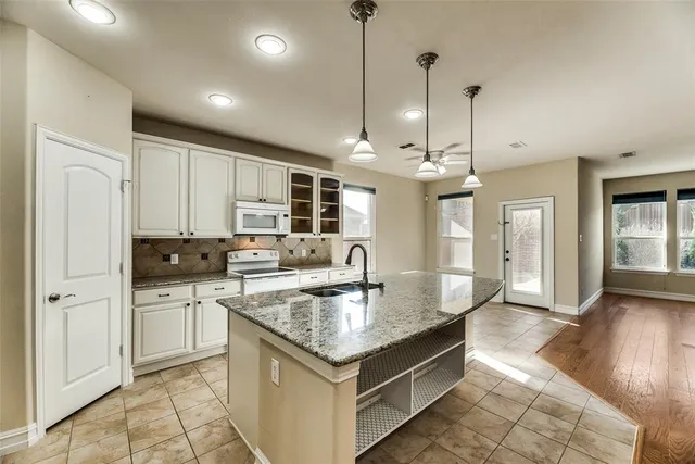 a kitchen with stainless steel appliances granite countertop a sink a stove and a refrigerator