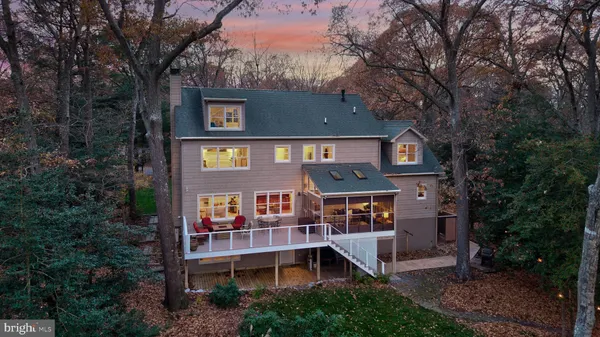 an aerial view of a house with balcony and trees al around