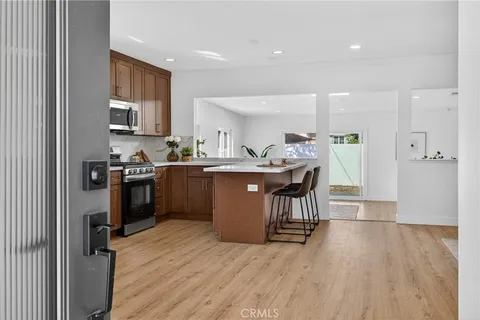 a kitchen with a sink a counter top space stainless steel appliances and a window