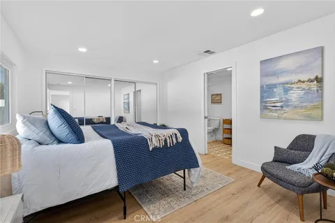 a large bedroom with a bed and wooden floor
