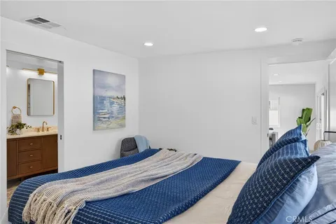 a bedroom with a bed and a painting on the wall