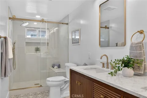 a bathroom with a granite countertop sink a toilet and shower