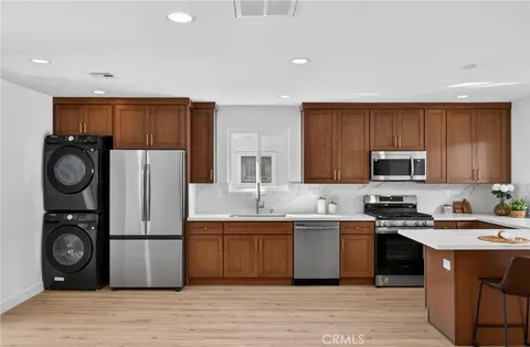 a kitchen with stainless steel appliances granite countertop a refrigerator a stove top oven a sink and dishwasher
