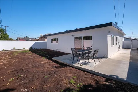 a roof deck with table and chairs and potted plants