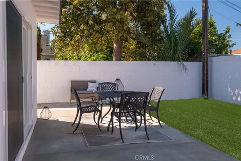 a backyard of a house with table and chairs