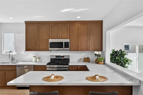 a kitchen with a sink a stove and white cabinets