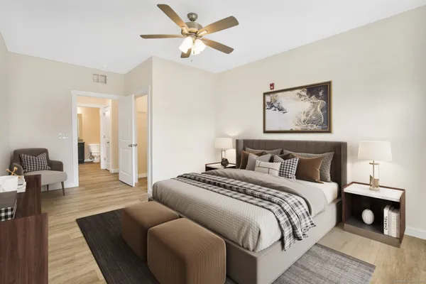 a spacious bedroom with a bed and wooden floor