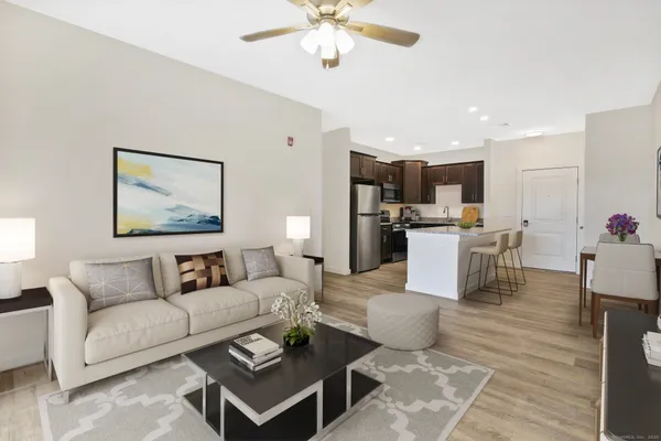 a living room with furniture a kitchen view and a chandelier