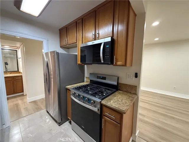 a kitchen with granite countertop stainless steel appliances a sink stove and cabinets