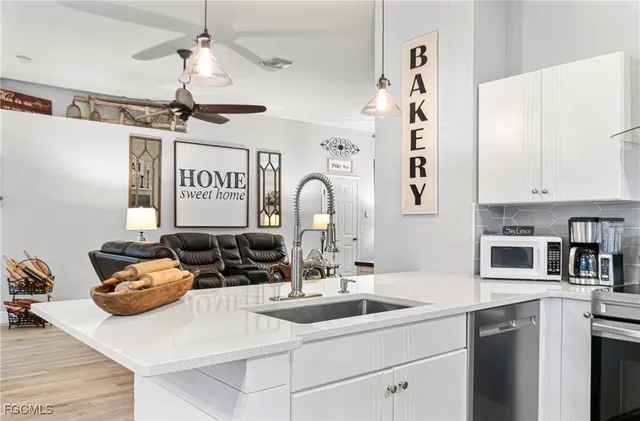 a kitchen with a sink appliances and cabinets