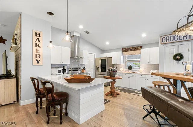 a kitchen with a table chairs stove and white cabinets