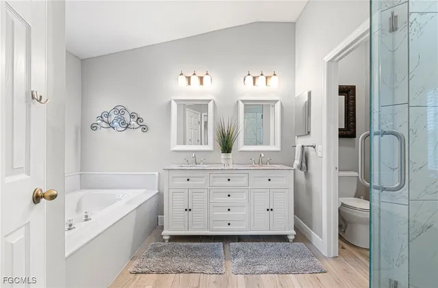 a spacious bathroom with a tub sink and mirror