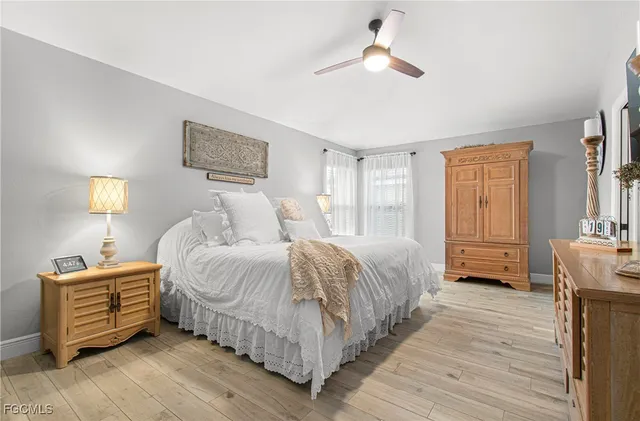 a bedroom with a bed chandelier and a window