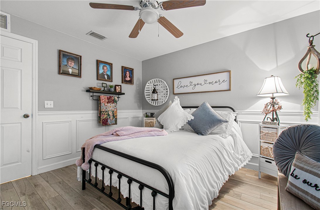 4656 Varsity Circle Lehigh Acres, FL 33971 - Photo 32 of 49 a bedroom with a bed a painting on the wall and dresser