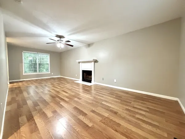 a view of an empty room with a window and fireplace