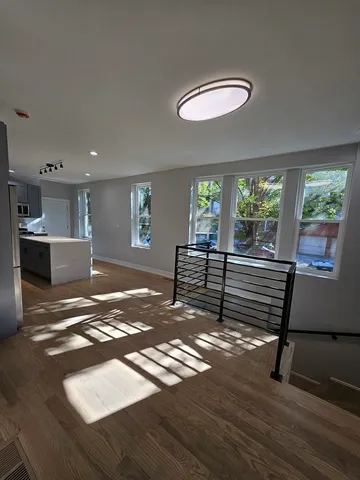 a view of a room with wooden floor and windows