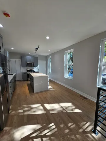 a living room with stainless steel appliances furniture and a window