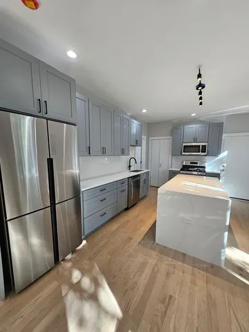 a kitchen with stainless steel appliances a refrigerator and a stove top oven