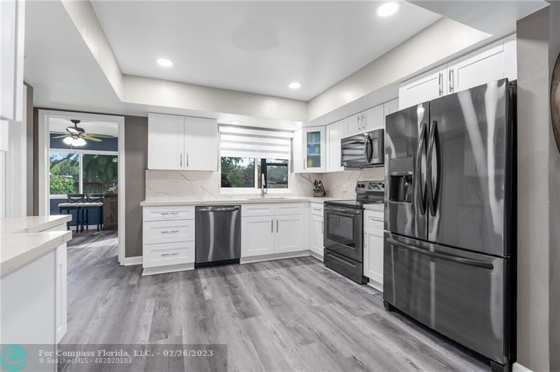 a kitchen with stainless steel appliances a refrigerator sink and cabinets