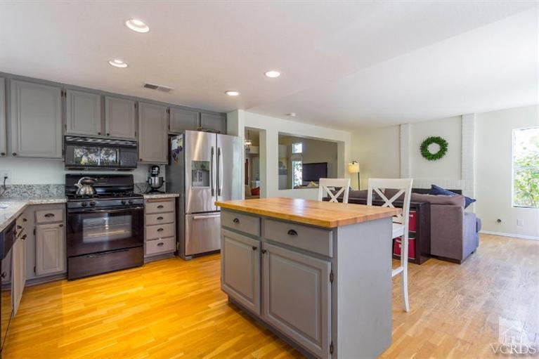 560 Fairfield Road Simi Valley, CA 93065 - Photo 11 of 32 a kitchen with stainless steel appliances kitchen island granite countertop a stove refrigerator and cabinets