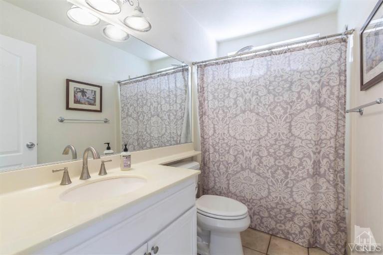 560 Fairfield Road Simi Valley, CA 93065 - Photo 26 of 32 a bathroom with a sink a toilet a mirror and shower curtain