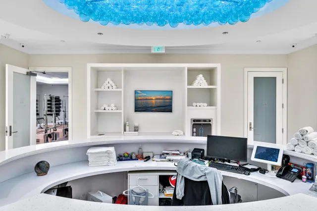 a kitchen with a stove a sink a refrigerator and a dining table with wooden floor