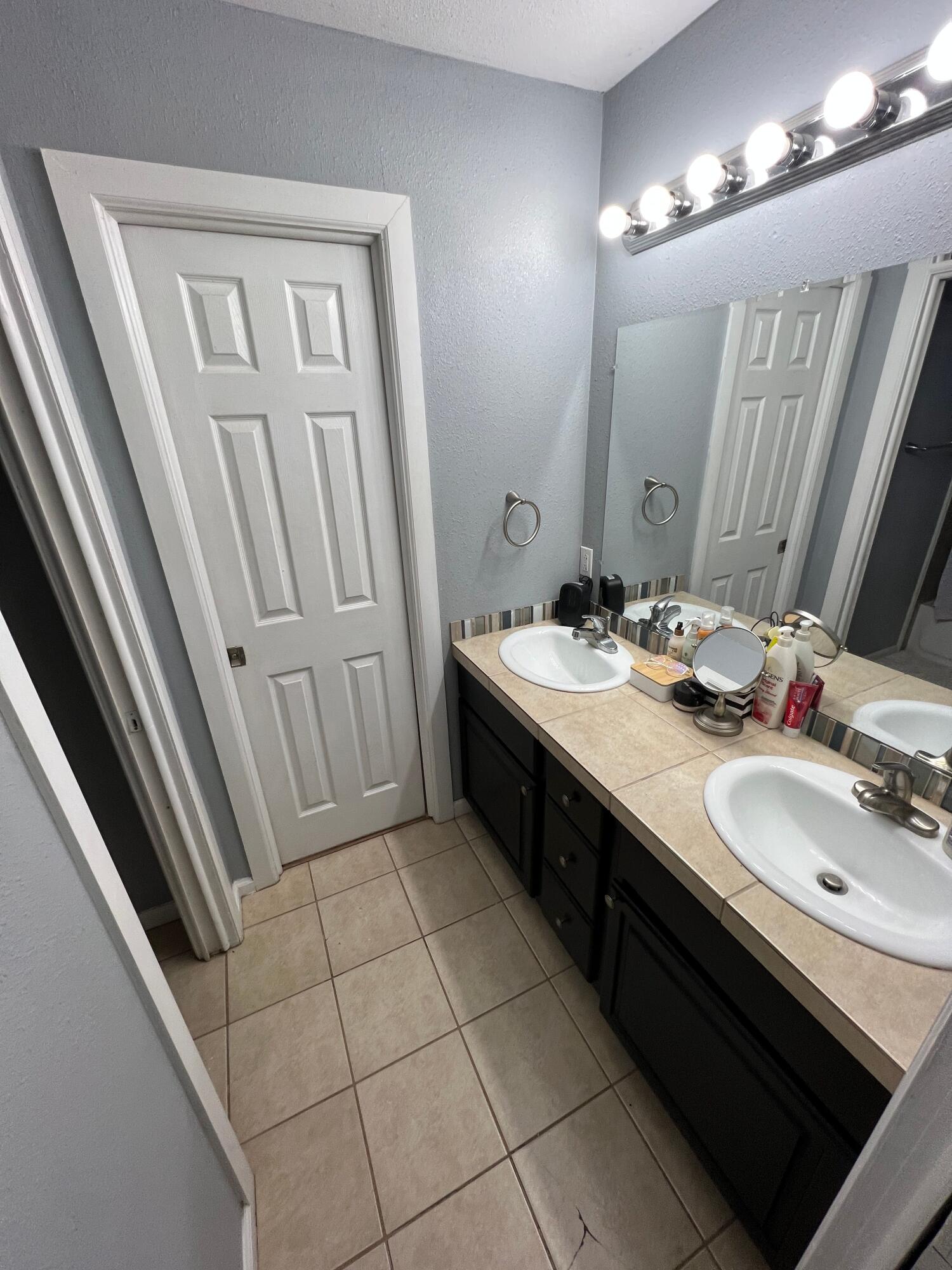 2312 15th Street Lubbock, TX 79401 - Photo 11 of 20 a bathroom with a double vanity sink and a mirror