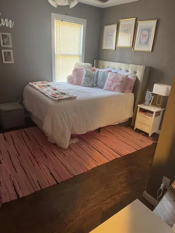 a bedroom with a bed and wooden floor