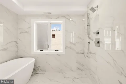 a white bath tub sitting in a bathroom next to a window