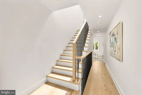 a view of a hallway with a livingroom and wooden floor