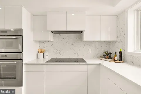 a kitchen with stainless steel appliances granite countertop a sink stove and white cabinets