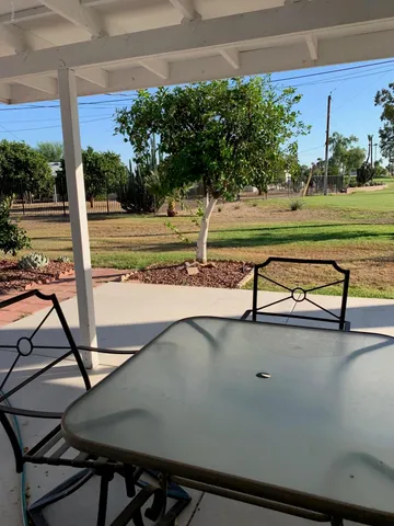 a view of a swimming pool with a yard and sitting area