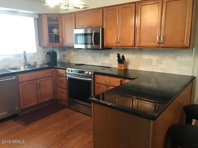 a kitchen with stainless steel appliances granite countertop a sink stove and microwave