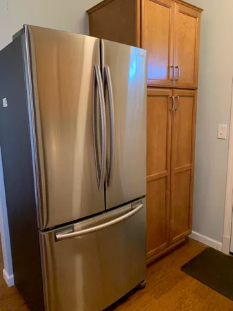 an empty refrigerator with wooden floor