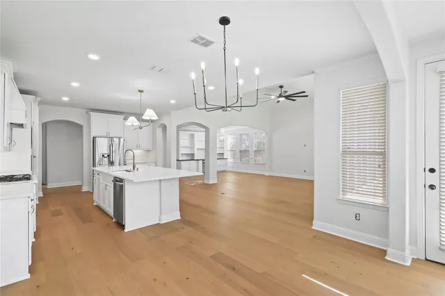 a kitchen with a sink a counter top space stainless steel appliances and cabinets