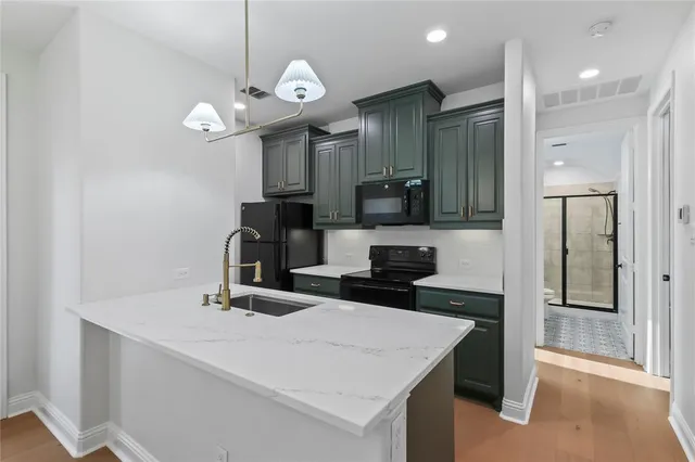 a kitchen with a sink a chandelier and a stove top oven